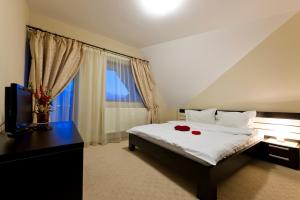 a bedroom with a bed with two red roses on it at VILA Restaurant Transilvania in Zărneşti