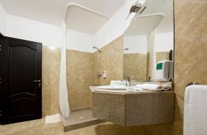 a bathroom with a sink and a large mirror at VILA Restaurant Transilvania in Zărneşti +57 photos