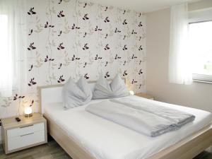ein Schlafzimmer mit einem weißen Bett mit Blumentapete in der Unterkunft Apartment Fuchs - DON160 by Interhome in Donnerskirchen