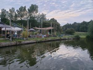 a group of people sitting at tables by a river at Duinnest in Noordwijkerhout
