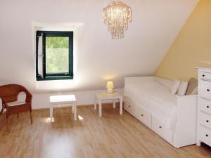 a bedroom with a bed and a chair and a chandelier at Holiday Home Hofgasse - MOE112 by Interhome in Mörbisch am See