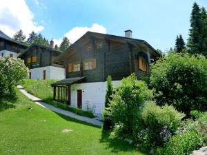 ein Haus auf einem Hügel mit einem grünen Hof in der Unterkunft Chalet Allegra by Interhome in Grächen