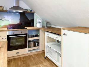 uma cozinha com balcões de madeira e um forno com placa de fogão em Apartment Knaushof - RMU200 by Interhome em Ramsau am Dachstein