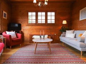 - un salon avec un canapé et une table dans l'établissement Chalet Chalet Merymont by Interhome, à Villars-sur-Ollon