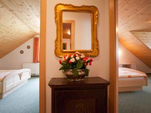 a bedroom with a mirror and a table with flowers at Apartment Salzmannhof - RMU210 by Interhome in Ramsau am Dachstein
