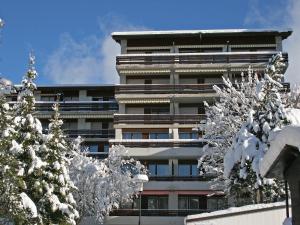 a building with snow covered trees in front of it at Apartment Gamat 30 by Interhome in Villars-sur-Ollon