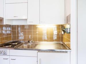 a kitchen with a sink and white cabinets at Studio Résidence Arzinol by Interhome in Les Collons