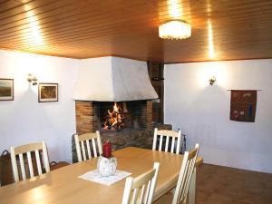 une salle à manger avec une table et une cheminée dans l'établissement Apartment Les Grangettes by Interhome, à Auberson