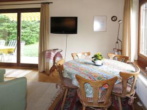 a dining room with a table with chairs and a television at Holiday Home Reier by Interhome in Seeboden