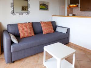 Apartment Les Girolles B14 by Interhome في فيلار سور أولون: غرفة معيشة مع أريكة زرقاء وطاولة