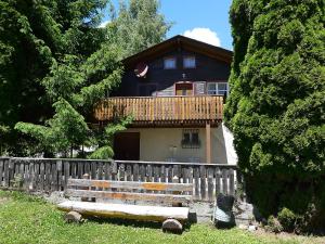 a house behind a fence with a bench in front of it at Chalet Zur Säge by Interhome in Albinen