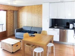 a kitchen and a living room with a table and a couch at Apartment Mirabeau by Interhome in Les Collons