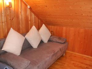 3 Kissen auf einer Couch in einer Hütte in der Unterkunft Apartment Les Fougères by Interhome in Les Rasses