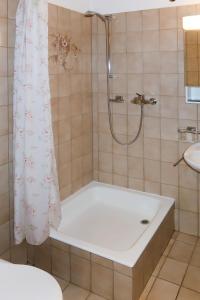 een badkamer met een bad en een douche met een douchegordijn bij Studio Hameau D12 by Interhome in Les Collons