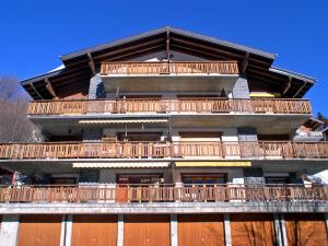 a tall building with wooden balconies on the side of it at Apartment Jorasse C 20 by Interhome in Ovronnaz