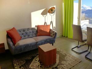 a living room with a couch and a table at Apartment Jeanne D'Arc Apt- C-28 by Interhome in Crans-Montana +37 photos