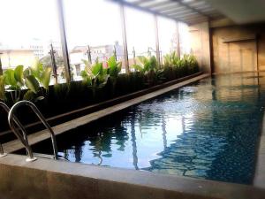 a large swimming pool in a building with water at Serela Waringin by KAGUM Hotels in Bandung