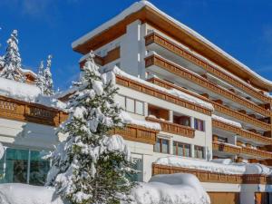 a building with snow covered trees in front of it at Apartment Christina 305 by Interhome in Crans-Montana
