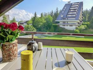 un tavolo bianco con un vaso di fiori sul balcone di Apartment Victoria A-B-C-3 by Interhome a Crans-Montana