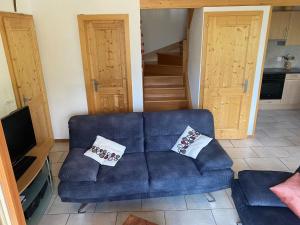 a living room with a blue couch with two pillows at Chalet Escapade by Interhome in Ovronnaz