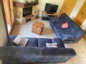 a living room with two blue couches and a fireplace at Chalet Escapade by Interhome in Ovronnaz +11 photos