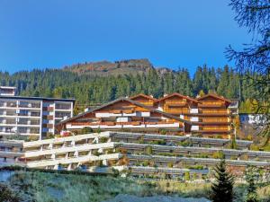 a large building with a mountain in the background at Apartment Terrasse des Alpes-17 by Interhome in Vermala