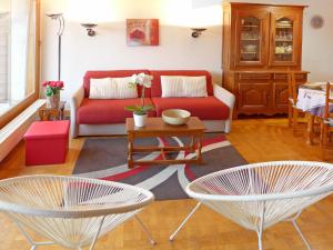 a living room with a red couch and two chairs at Apartment Terrasse Des Alpes 708 by Interhome in Vermala