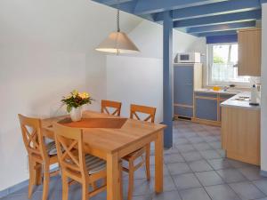 ドルム・ノイフェルトにあるHoliday Home Cuxland Ferienpark-1 by Interhomeのキッチン(木製ダイニングテーブル、椅子付)