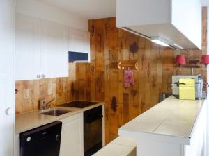 a kitchen with white cabinets and a sink at Apartment Centaure B RS 2 by Interhome in Ovronnaz