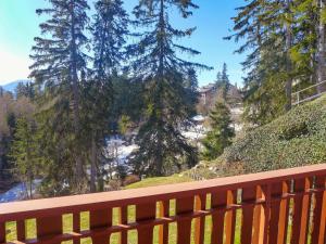 a wooden bench sitting on top of a hill with trees at Apartment Les Faverges 5 by Interhome in Crans-Montana