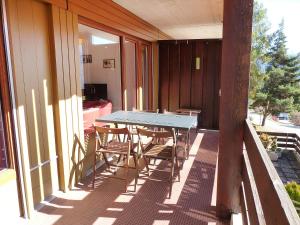 a table and chairs on the balcony of a house at Apartment Centaure B RS 2 by Interhome in Ovronnaz
