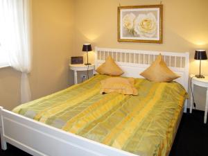 um quarto com uma cama com um edredão amarelo e verde em Holiday Home Klipper by Interhome em Burhave