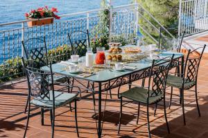 a table with chairs and a table with food on it at Villa Eris Amalfi Coast in Conca dei Marini