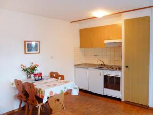 eine Küche mit einem Tisch, einem Tisch und Stühlen in der Unterkunft Apartment Châtillon C 16 by Interhome in Ovronnaz