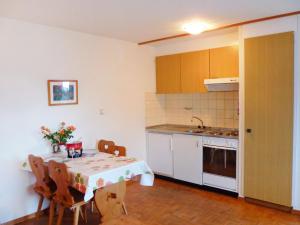 a kitchen with a table and a table and chairs at Apartment Châtillon C 16 by Interhome in Ovronnaz