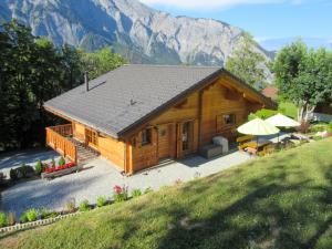 una cabaña de madera con una montaña en el fondo en Chalet Helene by Interhome, en Ovronnaz