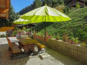 una mesa de picnic y una sombrilla en un jardín en Chalet Helene by Interhome, en Ovronnaz 27 fotos más