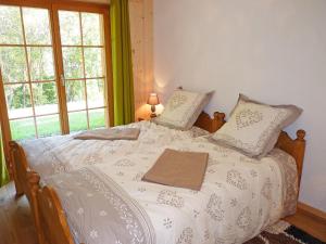 Un dormitorio con una cama blanca con almohadas y una ventana. en Chalet Helene by Interhome, en Ovronnaz