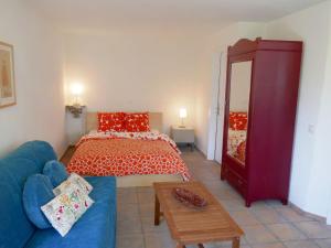 ein Wohnzimmer mit einem Bett und einem blauen Sofa in der Unterkunft Apartment Nelly by Interhome in Ponto Valentino