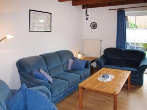 ein Wohnzimmer mit 2 blauen Sofas und einem Couchtisch in der Unterkunft Holiday Home Kitowski by Interhome in Hooksiel