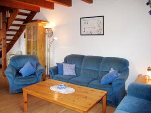 ein Wohnzimmer mit 2 blauen Sofas und einem Couchtisch in der Unterkunft Holiday Home Kitowski by Interhome in Hooksiel