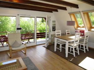 WilhelmsdorfにあるHoliday Home Svea by Interhomeのリビングルーム(テーブル、椅子付)、バルコニーが備わります。