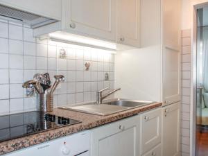 een keuken met witte kasten en een spoelbak bij Apartment Lido App- 46 by Interhome in Locarno