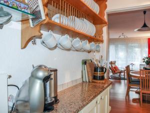 een keuken met witte kopjes en borden aan de muur bij Apartment Lido App- 46 by Interhome in Locarno +21 foto's