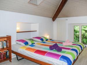 - une chambre avec un grand lit et des oreillers colorés dans l'établissement Apartment Appartamento Tazzino by Interhome, à Locarno
