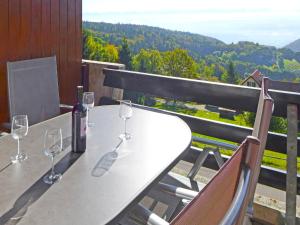 a table with wine glasses on a balcony with a view at Apartment Centaure-3 by Interhome in Les Rasses