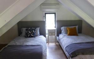 two beds in a room with an attic at Mansfield on the Manning in Tinonee