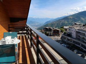 a balcony with a table and a view of a city at Apartment Les Platanes I5 by Interhome in Nendaz