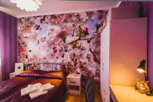 1 dormitorio con una pared de flores rosas en Tri Zaytsa en Murmansk