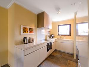 a kitchen with white cabinets and a window at Apartment Residenza Giardino by Interhome in Ascona